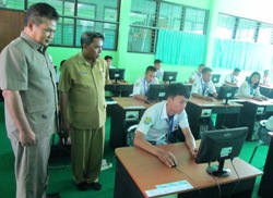 Kadis Pendidikan Kabupaten Situbondo, DR Fathor Rakhman saat memantau pelaksanaan UN online di SMKN I Panji, pagi kemarin (13/4). [sawawi/bhirawa].