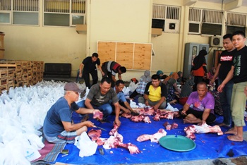 Tampak sejumlah karyawan PLN sedang sibuk melakukan proses pembagian daging kurban untuk warg yang kurang mampu. (Achmad Basir/bhirawa)