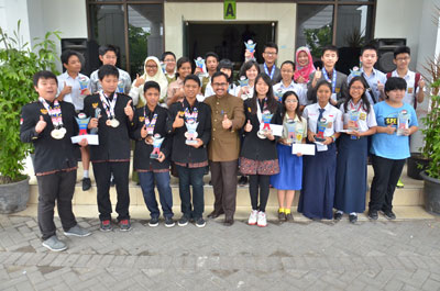 Para siswa peraih juara dalam ajang OSN dan IMSO memamerkan trophy dan medali kemenangan mereka bersama Kepala Dindik Surabaya Ikhsan.