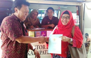Kepala BPN Nandang Agus Taruna memberikat sertifikat yang sudah jadi kepada warga.(achmad suprayogi/bhirawa)