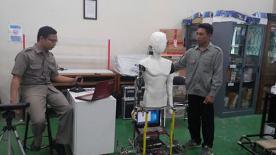 Syamsiar Kautsar mencoba fungsi robot berbentuk manusia hasil riset yang dilakukannya di laboratorium PPNS.