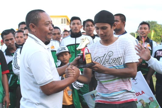 Ketua Umum Bumi Wali FC, H Moh.Muhbib saat menyerahkan piala penghargaan pada pemain terbaik dalam  kompetisi Bupati Tuban Cup 2016. (Khoirul Huda/bhirawa)