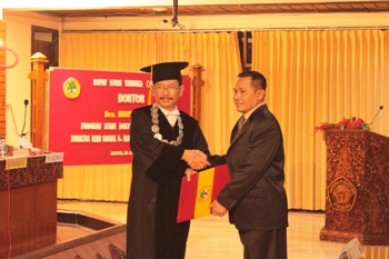 Kabid Pendidikan Menengah Kejuruan Dinas Pendidikan (Dindik) Jatim Dr Hudiyono MSi menerima piagamdoktoral dari ketua dewan penguji Prof Agus Sukristyanto. [adit hananta utama/bhirawa]