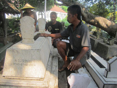 Suherman beserta warga setempat membersihkan Makam Sarinah di Pemakaman Kelurahan Kepatihan Kota Tulungagung, Selasa (19/1).