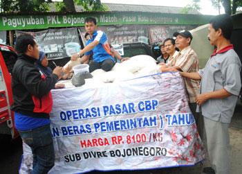 Petugas Bulog Sub Divre Bojonegoro saat menggelar operasi pasar di kompleks Pasar kota Bojonegoro.