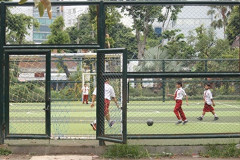 Sejumlah pelajar SDN Ketabang bermain sepak bola di lapangan futsal milik Pemkot Surabaya yang ada di Taman Apsari sepulang sekolah, Selasa (26/1) kemarin. [Syafruddin/Magang]