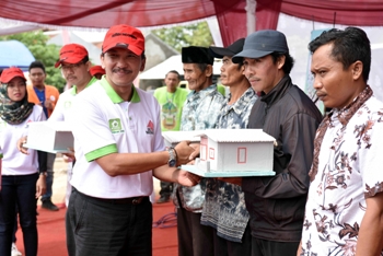 Kepala Departemen CSR Semen Indonesia, Wahyudi Heru secara simbolis menyerahkan bantuan rumah layak huni untuk warga. [rokim/bhirawa]