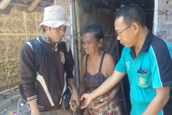 Nenek Armona, didampingi tetangganya Artiono dan pemerhati masalah sosial saat menyerahkan bantuan, kemarin. [sawawi/bhirawa].