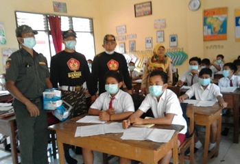 Anggota LPBI NU dan Banser NU Kabupaten Malang saat membagikan masker pada siswa  sekolah di wilayah Kec Poncokusumo, Kab Malang.