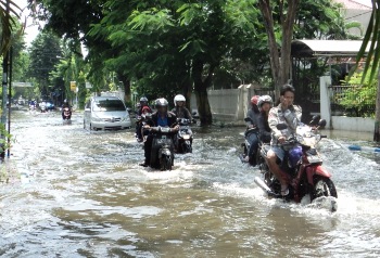 Terlihat nekat warga melewati Jl. Kartini Sidoarjo yang tergenang air alias banjir. (achmad suprayogi/bhirawa)