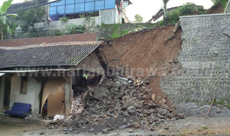 Rumah Musyafak rusak parah setelah tertimpa longsoran tebing di Jalan Raya Nganjuk-Sawahan, Selasa (16/2). [ristika]