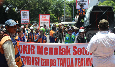 Ratusan juru parkir (jukir) yang tergabung dalam Paguyuban Parkir Surabaya (PJS) demo di depan Gedung DPRD Kota Surabaya, Rabu (24/2) kemarin. [gegeh bagus]
