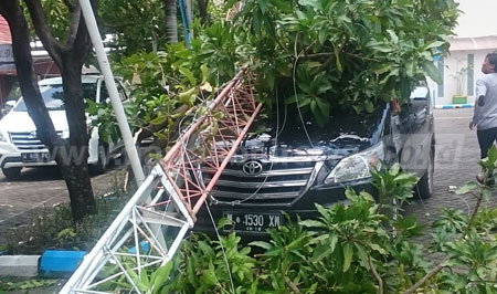 Mobil Toyota Innova milik Bambang tertimpa tiang repeater, Kamis (25/2). [hadi suyitno]