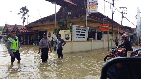 Genangan air masih melumpuhkan 13 kelurahan/desa di Kabupaten Sampang, Minggu (28/2). Banjir dua hari mengakibatkan aktivitas roda perekonomian warga lumpuh total. Bahkan arus lalu lintas yang menghubungkan ke Kabupaten Bangkalan dan Pamekasan nyaris terputus. [nurkholis]