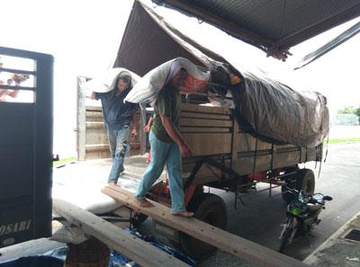 Dua pekerja nampak mengangkut beras Import asal Vietnam ke salah satu gudang bulog di Jombang. 