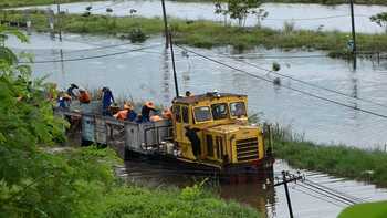 Suasana perbaikan atau peninggian rel kereta api di Porong yang masih tertutup air. [achmad suprayogi/bhirawa]