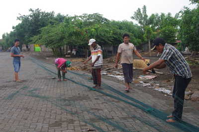 Sejumlah nelayan asal Desa Tanjung Pecinan, Kecamatan Mangaran, Kabupaten Situbondo lebih memilih memperbaiki jaring ikan karena cuaca akhir-akhir yang kian memburuk. [sawawi/bhirawa]