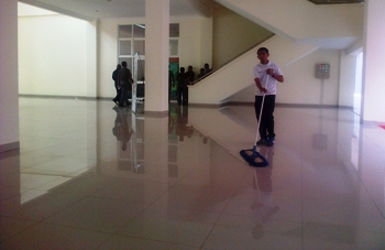 Salah satu petugas cleaning service Pemkot Batu sedang membersihkan bagian lobby Block Office (supriyanto/bhirawa)