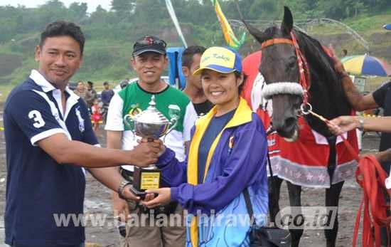 Aragon Stable Jabar, pemilik kuda Matah Ati KPI menerima Piala KONI Jatim, juara I di kelas A Terbuka 2000 meter. [wawan triyanto/bhirawa]