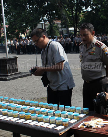 Petugas Polres Pasuruan Kota melihat hasil tes urin di Mapolres Pasuruan Kota, Senin (28/3).