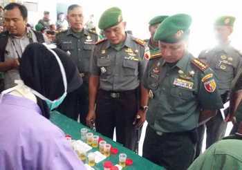Komandan Korem (Danrem) 084 Bhaskara Jaya, Kolonel CZI Denny Herman, memeriksa hasil tes urine anggota Kodim 0817 Gresik. [rokim/bhirawa]