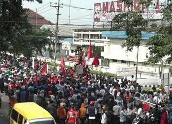 Massa Buruh Maspion demo di depan pabriknya sehingga memacetkan jalan raya. [Alikusyanto/bhirawa] 