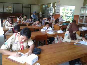 Sejumlah siswa SMP sedang menggarap soal-soal OSN di ruang kelas SMPN I Situbondo, Sabtu kemarin.  [sawawi/bhirawa].