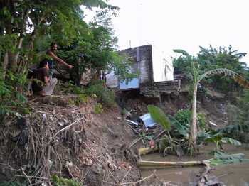 Salah satu titik rumah warga Desa Kebomlati Kecamatan Plumpang yang terancam longsor akibat tergerus air sungai bengawan solo. (khoirul Huda/bhirawa)