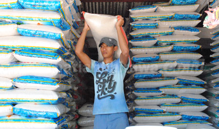 seorang pekerja sedang mengangkat beras di salaha satu pasar di Bojonegoro. [achmad basir]