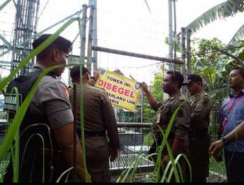 Satpol PP didampingi petugas kepolisian dan TNI melakukan penyegelan Tower di lingkungan Meri, Kota Mojokerto, Kamis (28/4) kemarin. [kariyadi/bhirawa]