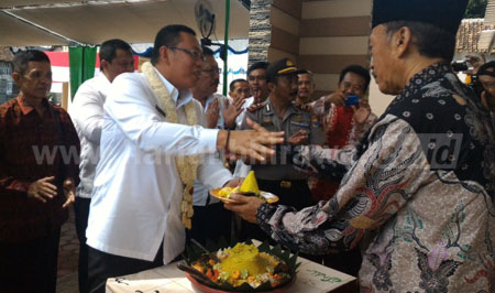 Bupati Situbondo, H Dadang Wigiarto SH menerima tumpeng dari Ketua KPRI Sentausa Asembagus, Akhmad Gunawan, saat peresmian gedung baru yang cukup representatif itu. [sawawi]