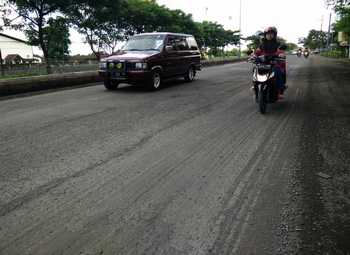 Sejumlah pengguna jalan melewati jalan yang rusak di Desa Raci, Kecamatan Bangil, Kabupaten Pasuruan, Kamis (21/4). Bupati Pasuruan meminta agar jalan tersebut segera diperbaiki. [hilmi husain/bhirawa]