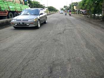 Kondisi jalan raya pantura Pasuruan-Surabaya, tepatnya di Desa Raci, Kecamatan Bangil, Kabupaten Pasuruan setelah dikeruk tak kunjung diperbaiki sehingga setiap harinya ada saja pengendara roda dua yang mengalami kecelakaan, Minggu (17/4). [hilmi husain/bhirawa]