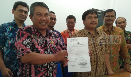 Kepala SMKN 12 Surabaya Abdul Rofiq menunjukkan surat tanda terima laporan polisi atas perkara penghinaan yang dituduhkan ke Kepala SMK Dr Soetomo Surabaya, Kamis (7/4).