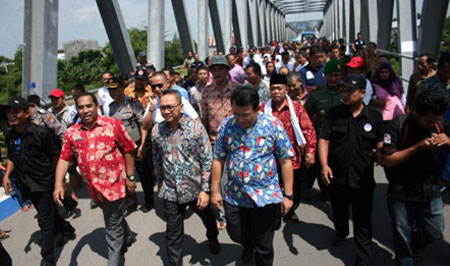 Ketua MPR Zulkifli Hasan (tengah) berjalan kaki dengan didampingi Bupati Bojonegoro Suyoto (kirinya) menyeberangi Jembatan Bengawan Solo usai diresmikan, Rabu (11/5). 