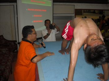 Pelatih Senam Puslatda Jatim, Indra Sibarani saat menunjukkan kepada peserta postur tubuh dan kelenturan tubuh yang dibutuhkan atlet senam. [wawan triyanto/bhirawa]
