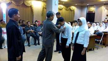 Plt Sekda Gresik, Bambang Isdianto tengah menyematkan tanda peserta Diklat kepada peserta Diklat. [kerin ikanto/bhirawa]