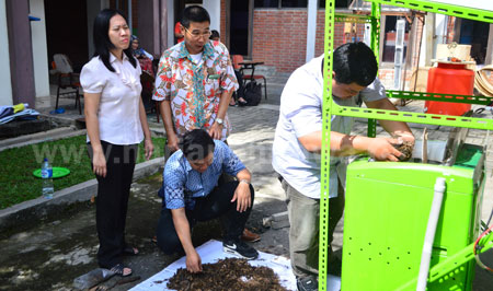 Andrew Juwono dan Lanny Agustine dibantu dua mahasiswanya mencoba kegunaan komposter tenaga surya ciptaannya di kampus UKWMS Jl Kalijudan, Kamis (9/6). [adit hananta utama]
