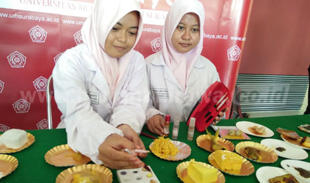 Dua mahasiswa analis kesehatan Universitas Muhammadiyah Surabaya mendemonstrasikan pulpen pendeteksi zat kimia ke bahan makanan yang dibeli dari pasar. [adit hananta utama]