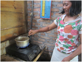 Salah seorang ibu rumah tangga Farida Antasari yang memasak dengan kompor yang menggunakan biogas. Tampak api kompor yang berwarna kebiru-biruan.