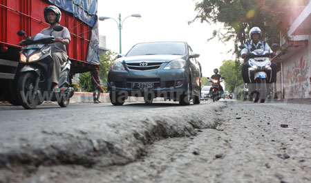 Sejumlah kendaraan baik roda dua dan empat melewati Jalan Soekarno - Hatta di Kota Pasuruan yang kondisinya bergelombang, Selasa (21/6) sore. [hilmi husain]