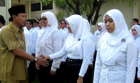 Bupati Pasuruan Irsyad Yusuf berjabat tangan kepada PNS di Kabupaten Pasuruan. DPKAD Kabupaten Pasuruan memastikan gaji 13 dan 14 untuk PNS dan PTT cair akhir Juni 2016.  [hilmi husain]