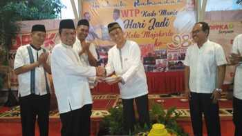 Wali kota Mas'ud Yunus menyerahkan tumpeng kepada Kepala DPPKA Agung Moeljono ketika buka bersama dan tasyakuran penghargaan WTP.n [kariyadi/bhirawa]