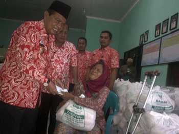 Wali kota Mas'ud Yunus menyerahkan zakat fitra kepada warga penerima zakatdi kelurahan Mentikan, Kamis (30/6) kemarin. (kariyadi/bhirawa)