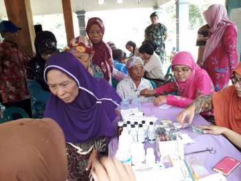 Puluhan ibu-ibu mendapat giliran antri lebih dahulu untuk mendapat pengobatan gratis dari Kodim 0815 Mojokerto di balai Desa Lakardowo.