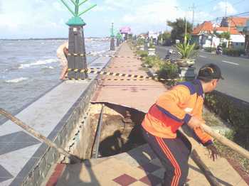 Tim reaksi cepat dari BPBD Kabupaten Tuban saat memberikan tanda pada titik lubang agar penguna jalan tidak terperosok. (Khoirul Huda/bhirawa)
