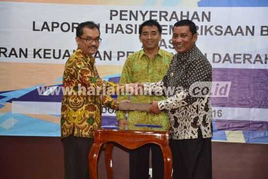 Bupati Syahri Mulyo ditemani Ketua Komisi B DPRD Tulungagung, Widodo Prasetyo, menerima laporan hasil pemeriksaan BPK atas LKPD Tahun 2015 dari Novian Herodwijanto, Selasa (31/5).