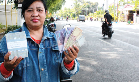 Penjual jasa penukaran uang yang menjajakan uang pecahan di pinggiran Jalan Balaikota, di Kota Pasuruan, Rabu (8/6). [Hilmi Husain]