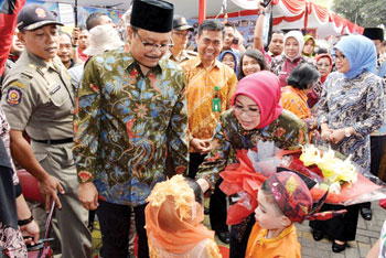 Wakil Gubernur Jatim H Saifullah Yusuf beserta Hj Fatma Saifullah Yusuf saat menerima seikat bunga dari penerima tamu cilik pada acara Hari Anak Nasional 2016 Provinsi Jawa Timur di Prigen Pasuruan.