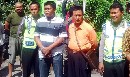 Anggota TNI AU Kopda Andika Nasution (baju bergaris hitam putih) diapit anggota Polsekta Nganjuk meminta maaf  di depan ratusan warga Kelurahan Bogo. [ristika]